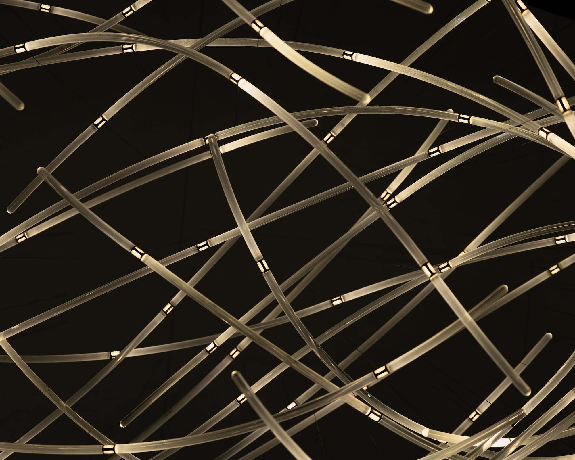 Close view of overlapping glass rods and illuminated joints in DRIFT’s Aeolus.