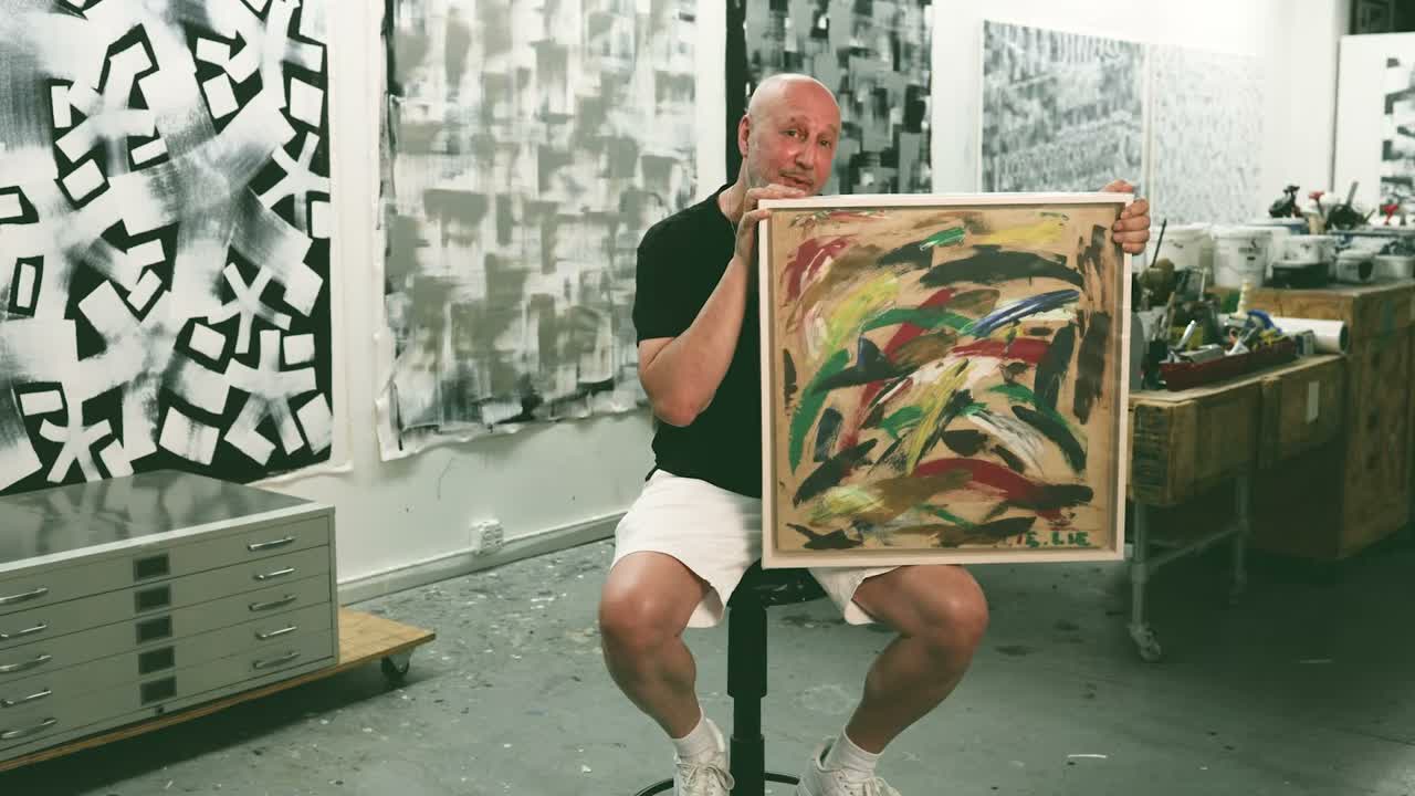 Eric Haze holding the abstract oil painting he made at age ten