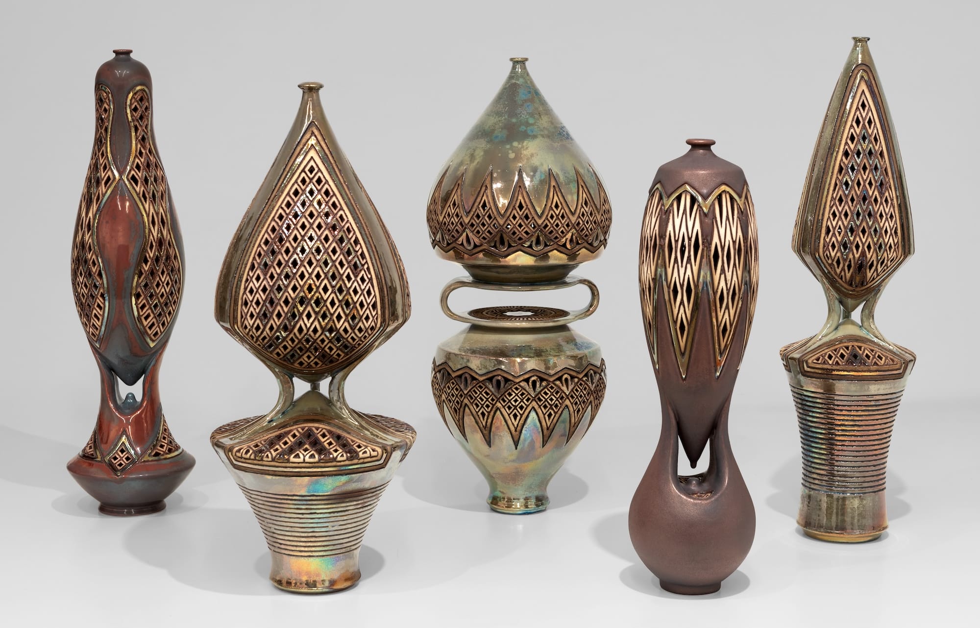 Five pierced ceramic sculptures by Ibrahim Said, with patterned bodies linked to narrow stems and bases.