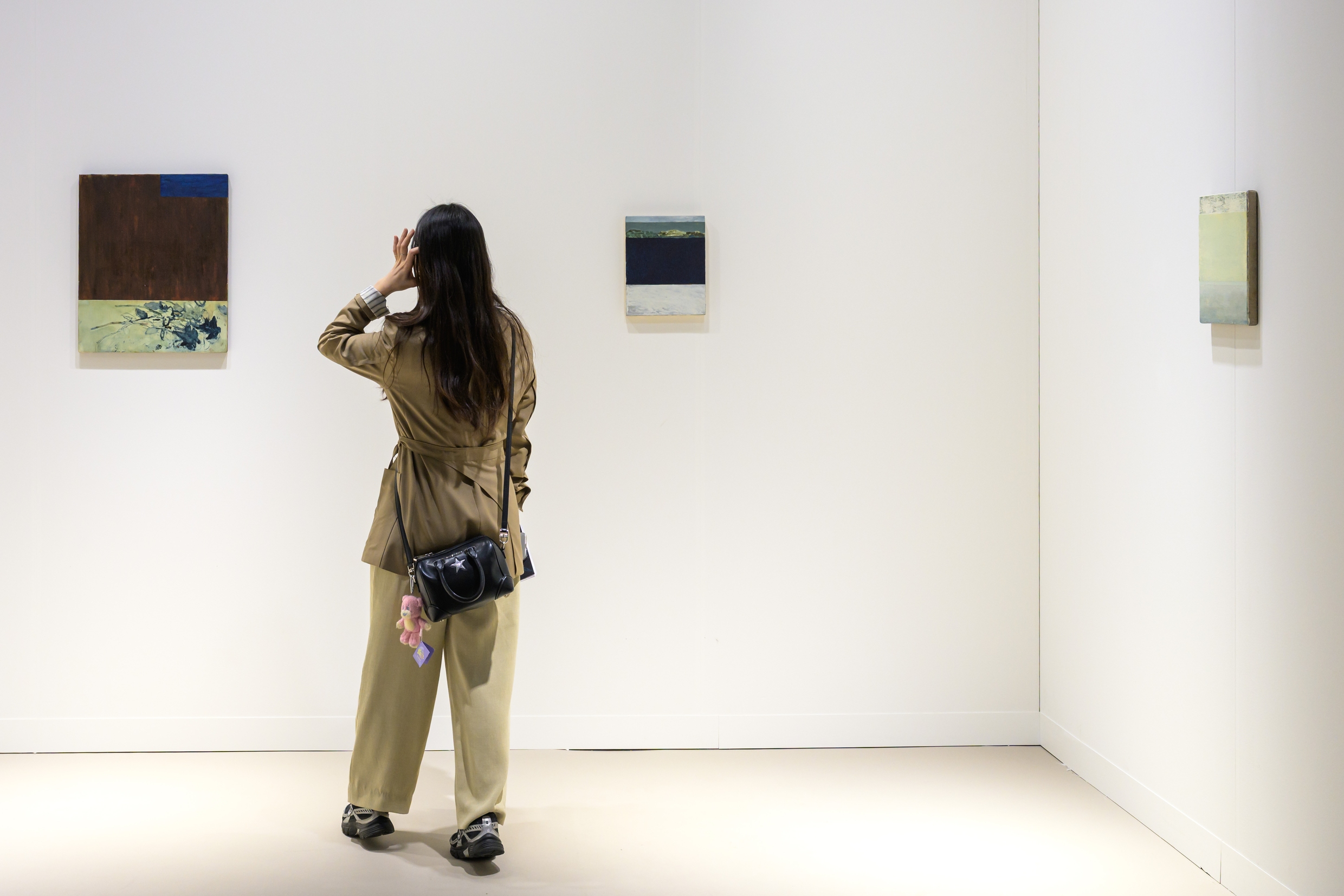 A visitor viewing paintings at Almeida and Dale's booth during Art Basel Hong Kong 2026