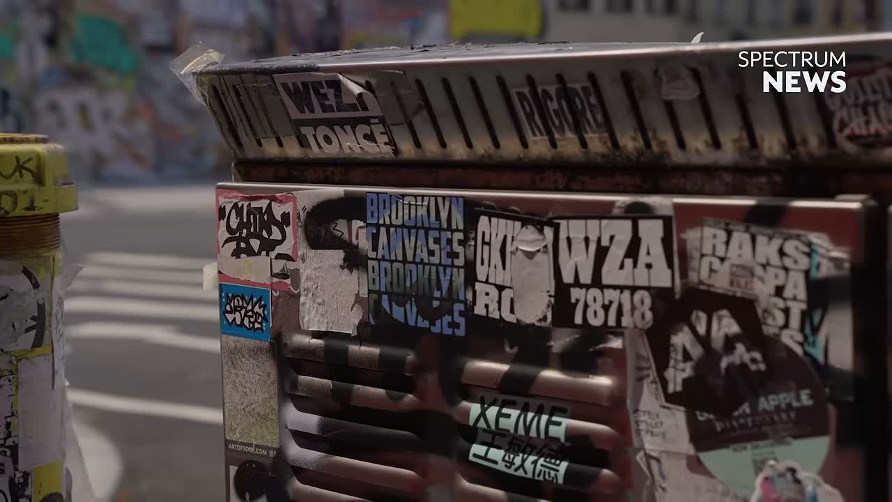 Layers of graffiti stickers covering a metal street fixture in New York City